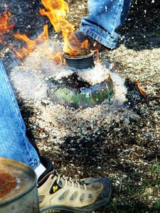 Scarpa vicino a fuoco all'aperto e pentola